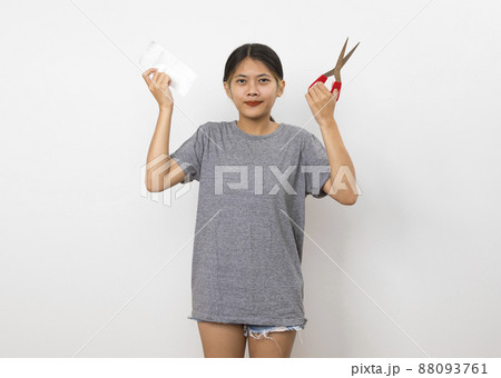 portrait of a young asian woman wisely manage household expense by cutting the bill on white background. 88093761