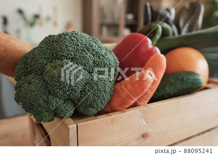 Close-up of fresh vegetables such as broccoli, carrots, cucumbers and bell pepper in wooden box 88095241