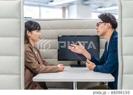 プライベートブースで話をするビジネスマンとビジネスウーマン 88096150