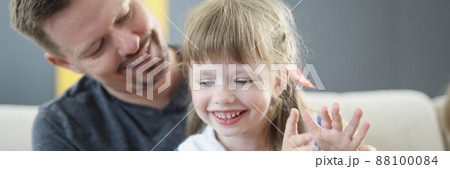 Dad playing with little daughter sitting on the couch Dad playing with little daughter sitting on the couch 88100084