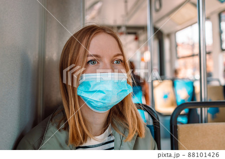 European 30s woman in protection face mask, public transport passenger, traveling in tram European 30s woman in protection face mask, public transport passenger, traveling in tram 88101426
