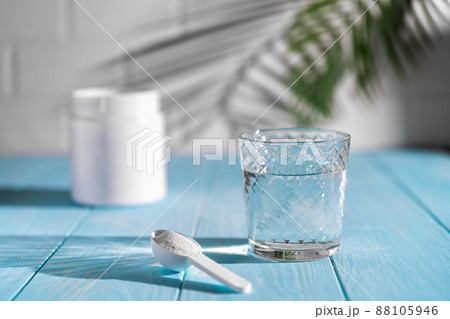 Collagen powder in spoon on wooden blue background. 88105946