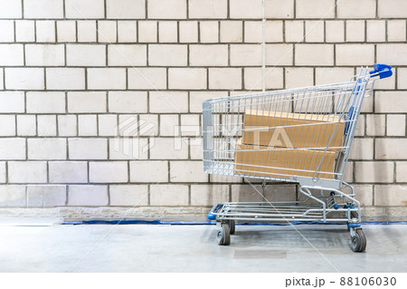 shopping cart with boxes in front of brick wall shopping cart with boxes in front of brick wall 88106030
