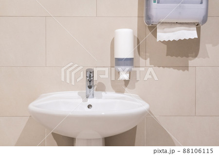 Sink next to soap dispenser pump and paper towel dispenser 88106115