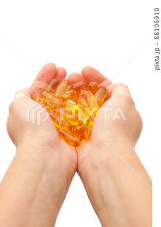 hands holding omega-3 fish fat oil capsules 88106910