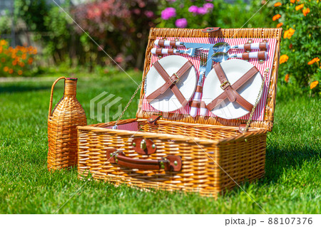 Picnic Wicker basket on green sunny lawn in the park 88107376