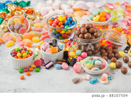 Milk chocolate candies woth shell in jar with various jelly gums candies  88107504
