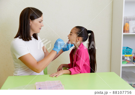 Speech therapist working with girl training pronunciation 88107756