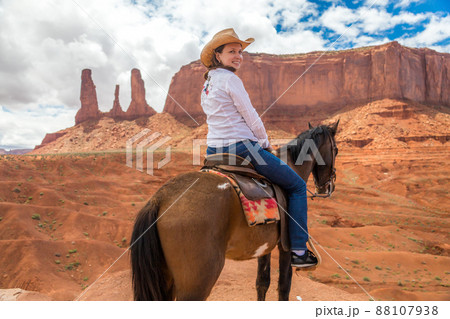 Cowgirl riding horse in Monument Valley Navajo Tribal Park in USA Cowgirl riding horse in Monument Valley Navajo Tribal Park in USA 88107938