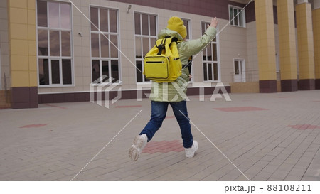 slow motion. schoolgirl with backpack hurries lesson on an autumn day. childhood education concept. school run kid girls. get back school quickly. children run through school yard education building slow motion. schoolgirl with backpack hurries lesson on an autumn day. childhood education concept. school run kid girls. get back school quickly. children run through school yard education building 88108211