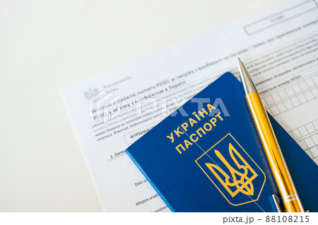 PESEL document, Ukrainian passport and a pen on white table background. PESEL document, Ukrainian passport and a pen on white table background. 88108215