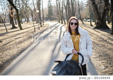 beautiful and young woman mother and baby in a stroller walking beautiful and young woman mother and baby in a stroller walking 88108899
