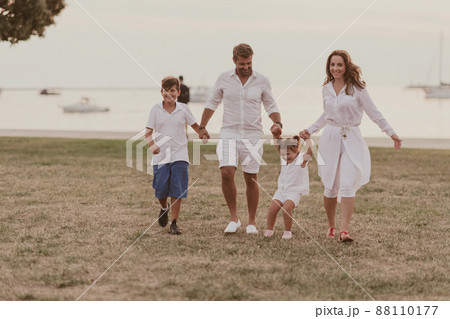 Senior couple in casual clothes with their children, boy and girl enjoy the beach spending a vacation together. Family time . Selective focus  88110177