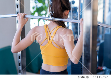 スポーツジムでトレーニングする若い女性 88110292