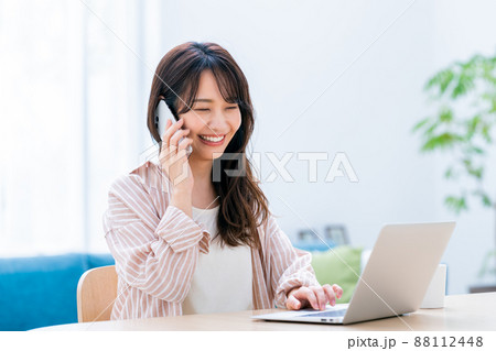 電話するテレワークの若い女性 電話するテレワークの若い女性 88112448
