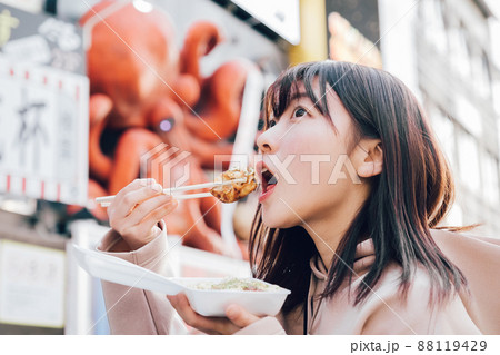大阪ミナミでたこ焼きを食べる女性 88119429