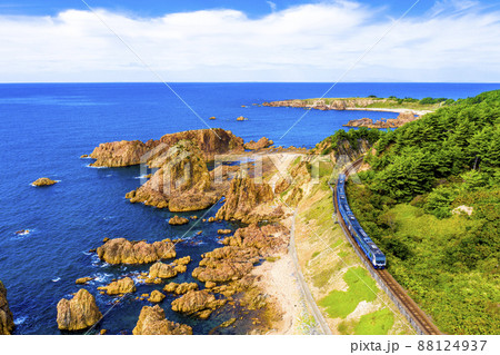 青森県 深浦町にある行合崎付近の奇岩沿いを走行するリゾート列車を俯瞰撮影	 88124937