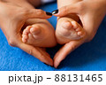 Hands of mother in the form of a heart on children's legs 88131465