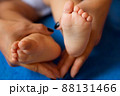 Hands of mother in the form of a heart on children's legs 88131466