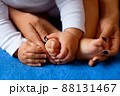 Hands of mother in the form of a heart on children's legs 88131467