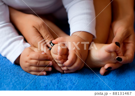 Hands of mother in the form of a heart on children's legs 88131467