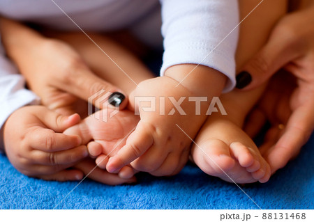 Hands of mother in the form of a heart on children's legs 88131468
