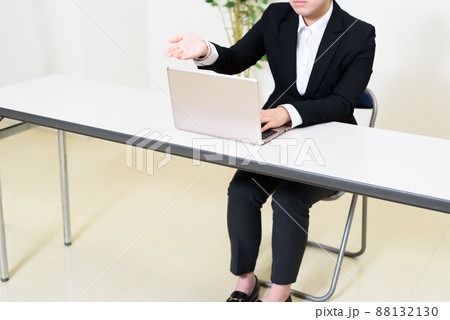 パソコンを見ながら会議室で面談、面接、会議をする若い女性 パンツスーツ パソコンを見ながら会議室で面談、面接、会議をする若い女性 パンツスーツ 88132130