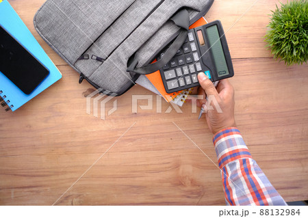 top view of young man putting office stationary in his bag top view of young man putting office stationary in his bag 88132984