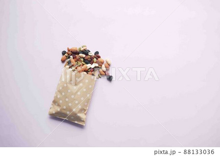 top view of many mixed nuts spilling a from a packet  88133036