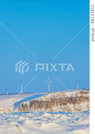 Wind farm in the Arctic on the sea coast. Wind turbines on a high rocky shore against a blue sky. Wind farm in the Arctic on the sea coast. Wind turbines on a high rocky shore against a blue sky. 88133852