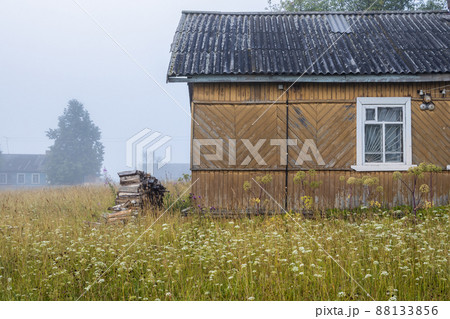 View of an old wooden house and a woodpile of firewood 88133856
