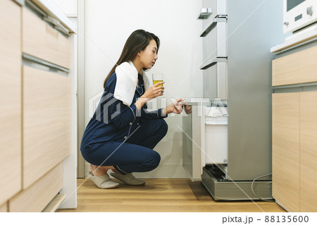 パジャマ姿で冷蔵庫を開ける女性 88135600