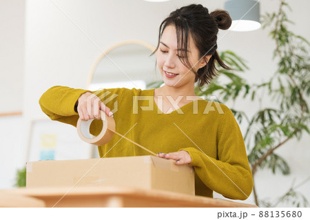 ダンボールにガムテープを貼る女性 ダンボールにガムテープを貼る女性 88135680