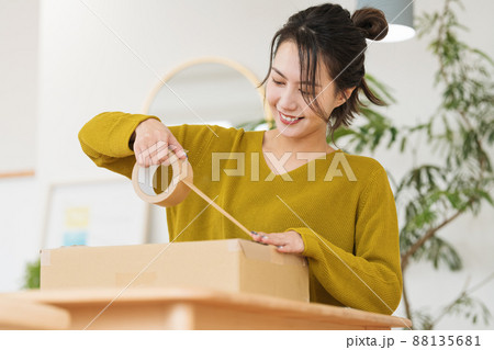 ダンボールにガムテープを貼る女性 ダンボールにガムテープを貼る女性 88135681