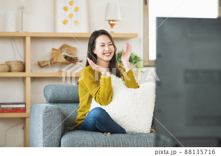 自宅のリビングでTVを楽しむ女性 自宅のリビングでTVを楽しむ女性 88135716