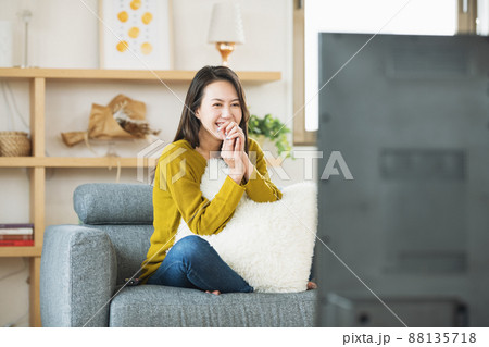 自宅のリビングでTVを楽しむ女性 自宅のリビングでTVを楽しむ女性 88135718