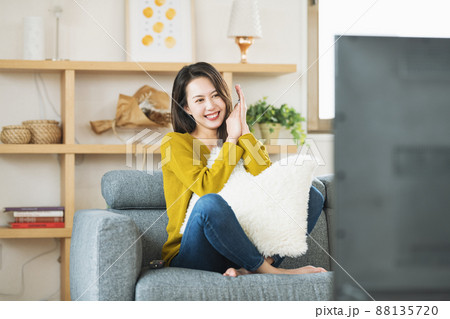 自宅のリビングでTVを楽しむ女性 88135720