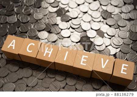 達成のイメージ｜「ACHIEVE」と書かれた積み木とコイン 88136279