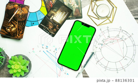 The concept of divination, magic and esotericism. Natal chart smartphone with Green screen tarot cards. The concept of divination, magic and esotericism. Natal chart smartphone with Green screen tarot cards. 88136301