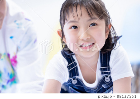 大きな画用紙に絵の具で絵を描く女の子 大きな画用紙に絵の具で絵を描く女の子 88137551