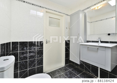 Bathroom with black and white wall tiles in modern home interior Bathroom with black and white wall tiles in modern home interior 88138424