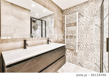 Luxurious bathroom interior with large sink and beige tiles Luxurious bathroom interior with large sink and beige tiles 88138486