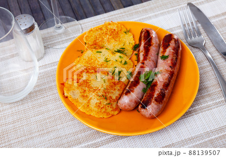 Just cooked potato pancakes with roasted sausages on plate Just cooked potato pancakes with roasted sausages on plate 88139507