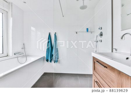 An amazing bathroom with snow-white tiles and a comfortable bathtub 88139629