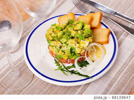 Salmon tartare with avocado and toasted bread 88139647
