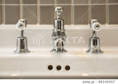 General view of metal valves and a sink faucet in a modern house 88140407