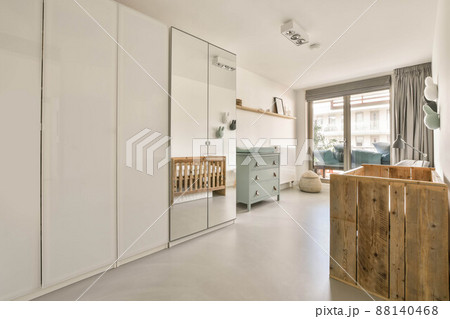 The interior of a modern cozy dressing room with large wardrobes and access to the balcony The interior of a modern cozy dressing room with large wardrobes and access to the balcony 88140468