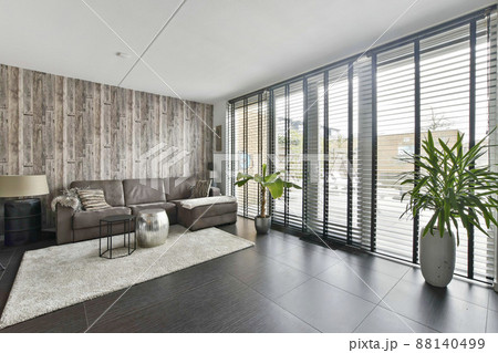 Living room with a large sofa with access to a spacious backyard in a new house Living room with a large sofa with access to a spacious backyard in a new house 88140499