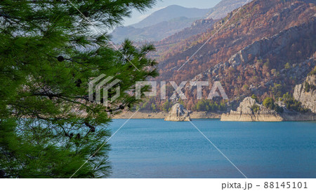 View from the slope to Oymapinar Dam through tree branches in Turkey View from the slope to Oymapinar Dam through tree branches in Turkey 88145101