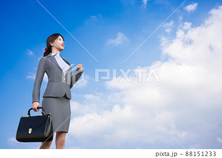 青空と白い雲を見上げガッツポーズのビジネスウーマン 青空と白い雲を見上げガッツポーズのビジネスウーマン 88151233